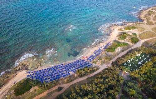 z góry widok na plażę z grupą stołów w obiekcie Meditur Puglia by Itafirst Hotels w mieście Specchiolla