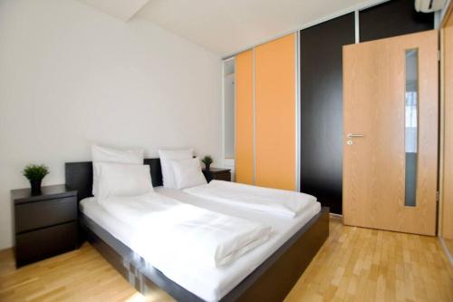 a bedroom with a large white bed and a door at Standard Apartment by Hi5 - Kazinczy street in Budapest