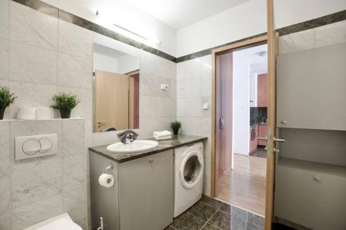 a bathroom with a washing machine and a sink at Standard Apartment by Hi5 - Kazinczy street in Budapest