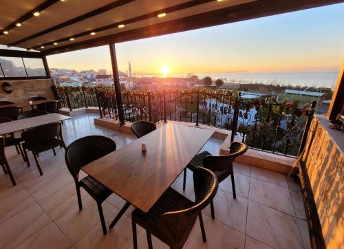 a table and chairs on a balcony with the sunset at Saruhan Hotel in Istanbul