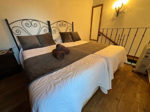 Un dormitorio con una cama grande con un osito de peluche. en Casa Pozo de la Nieve, en Iznatoraf
