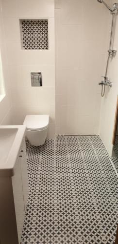 a bathroom with a black and white tiled floor at Tihase studio apartment with sauna in Tallinn