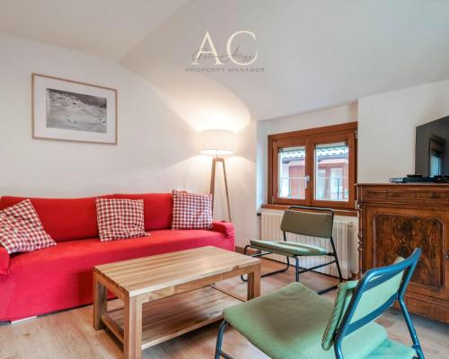 a living room with a red couch and chairs at Square Apartment in Ponte di Legno