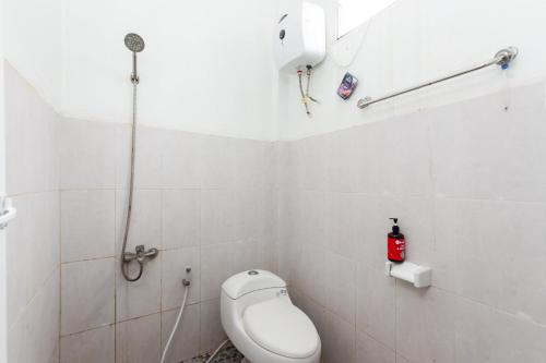 a small bathroom with a toilet and a shower at RedDoorz Syariah near RSUD Zainoel Abidin Banda Aceh in Banda Aceh