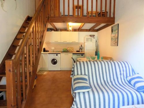 une petite cuisine avec un lit et un escalier dans l'établissement La Palmyre - CHALEUREUSE MAISON MITOYENNE - PROXIMITE CENTRE, aux Mathes