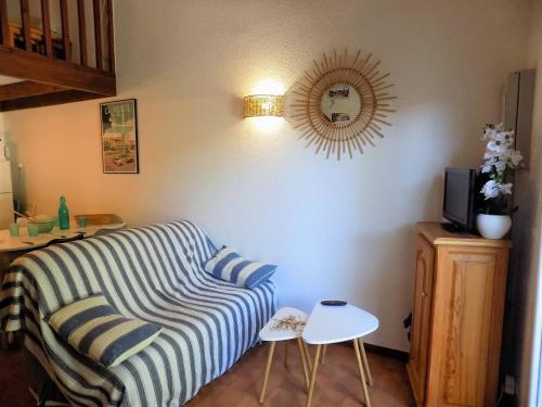 un salon avec un canapé et un miroir dans l'établissement La Palmyre - CHALEUREUSE MAISON MITOYENNE - PROXIMITE CENTRE, aux Mathes