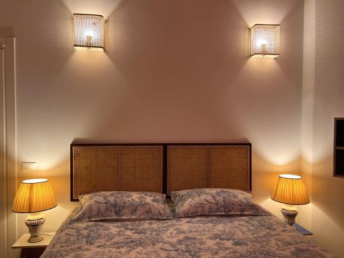 a bedroom with two lights on the wall and a bed at Garibaldina75 in Cesena
