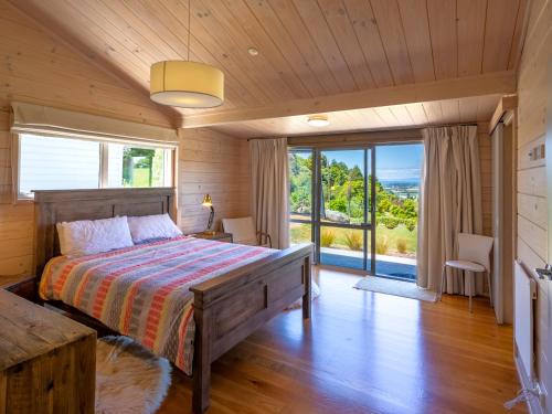 a bedroom with a bed and a large window at Paddock House - Motueka Holiday Home in Motueka