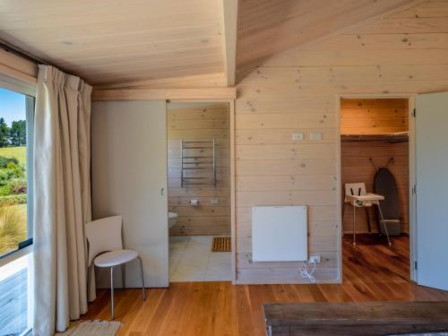 a room with wooden walls and a large window at Paddock House - Motueka Holiday Home in Motueka