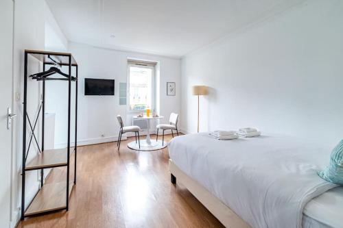 une chambre blanche avec un lit, une table et des chaises dans l'établissement Studio Proche Boulevard Voltaire, à Paris