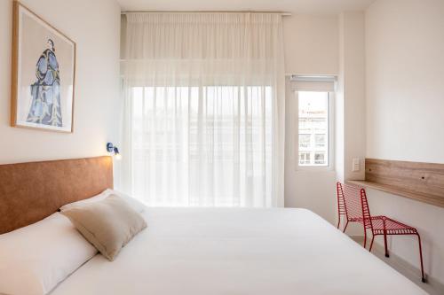 - une chambre avec un grand lit blanc et une fenêtre dans l'établissement Kallithea Apartments by Olala Homes, à Athènes
