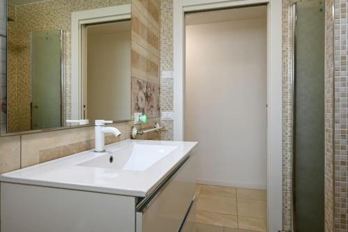 een badkamer met een witte wastafel en een spiegel bij Piazzola holiday home * * * * * 