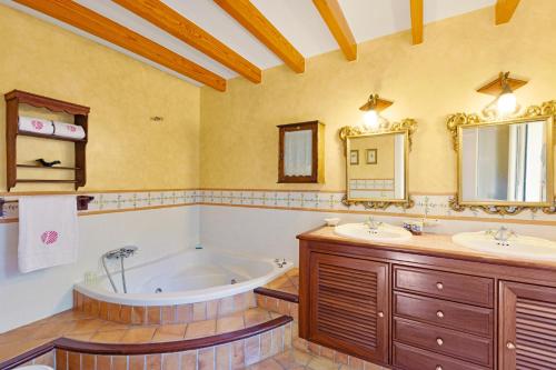 a bathroom with two sinks and a bath tub at Casa María in Santa Maria del Camí