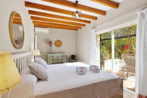 a bedroom with a white bed and a large window at Casa María in Santa Maria del Camí