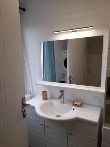 a bathroom with a sink and a mirror at Agréable maison de ville rénovée à Rouen in Sotteville-lès-Rouen