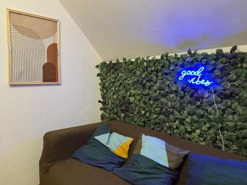 a couch in a room with a green wall at BoiKlo - Private pool, Billard, Spa Nordique 10p in Hellenvilliers