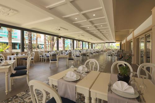 un restaurante con mesas blancas y sillas blancas en Crystal Paraiso Verde Resort & Spa - Ultimate All Inclusive, en Belek