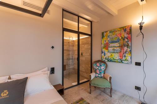 a bedroom with a bed and a chair at Tenuta Zamparina in Montignoso