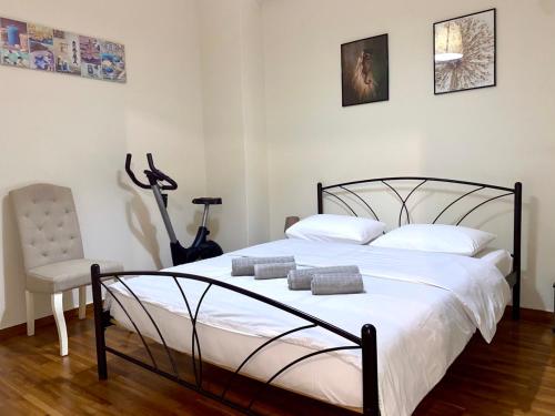 a bedroom with a large bed and a chair at Kallithea's breeze in Athens