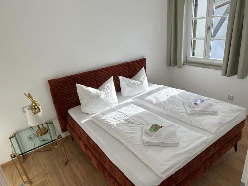 a bedroom with a bed with white sheets and pillows at muchhome LUXURY APARTMENTS - Stilvolle Apartments am Tegernsee in Gmund am Tegernsee