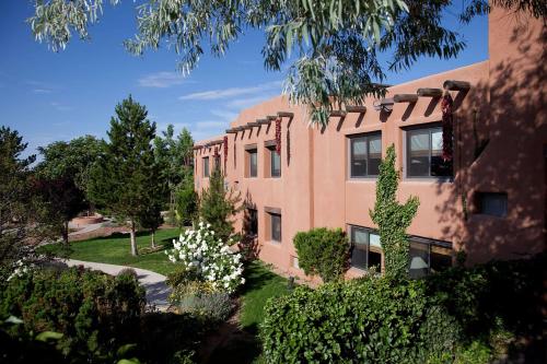 un immeuble d'appartements avec des arbres et des buissons devant lui dans l'établissement The Lodge at Santa Fe, à Santa Fe