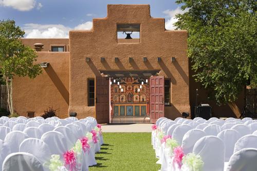 a row of white chairs in front of a building at The Lodge at Santa Fe in Santa Fe