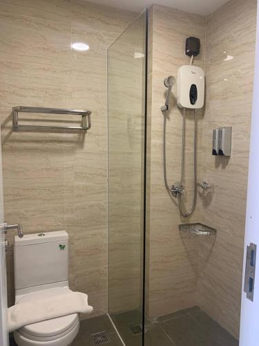 a bathroom with a glass shower with a toilet at ZX Service Apartment in Phnom Penh