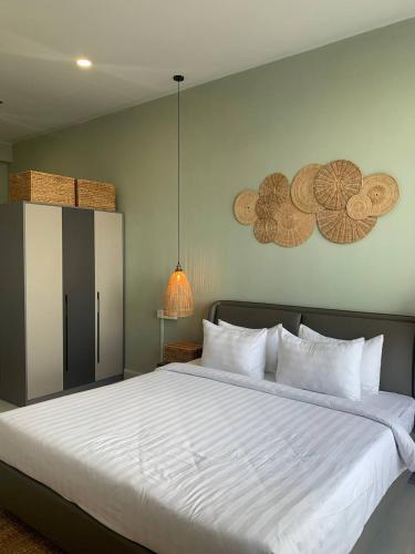 1 dormitorio con 1 cama grande con sábanas blancas en ZX Service Apartment, en Phnom Penh
