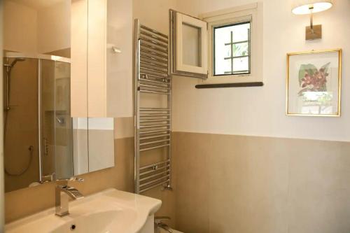 een badkamer met een wastafel, een toilet en een raam bij Tessa's holiday in Massa Lubrense