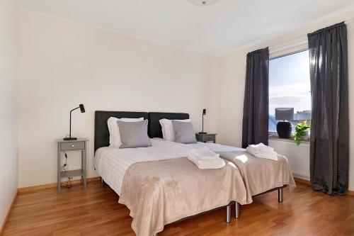 a white bedroom with a large bed and a window at Guestly Homes - 3BR Corporate Comfort in Boden