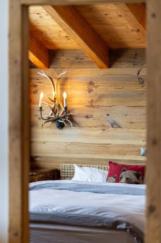 a bedroom with a bed with a wooden wall at Above the Clouds - spacious chalet with great view in Plan Fey