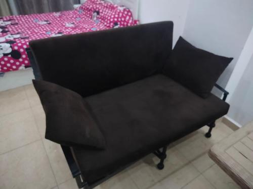a black chair sitting in a room with a bed at Hurghada City Apartment 3 in Hurghada