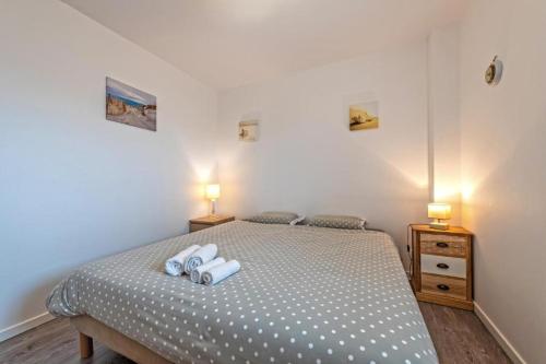 een slaapkamer met een bed met twee handdoeken erop bij résidence korejou plages in Plouguerneau