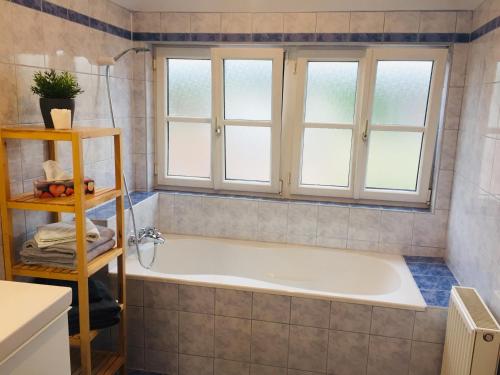 - Baño con bañera y 2 ventanas en Ruhige 3-Zimmer-Wohnung am Stadtrand mit Bergblick, en Salzburgo