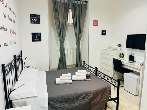 a bedroom with a bed with white pillows and a desk at ImeraRooms in Rome