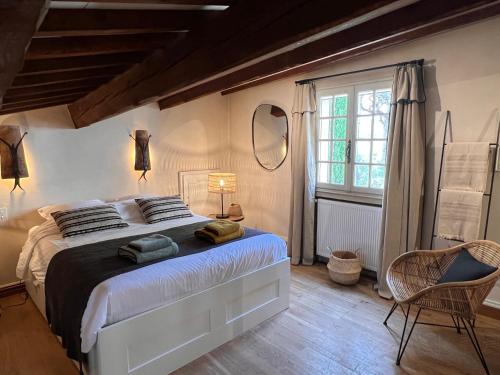 une chambre avec un grand lit et une fenêtre dans l'établissement Mas provençal dans les Alpilles, aux Baux-de-Provence