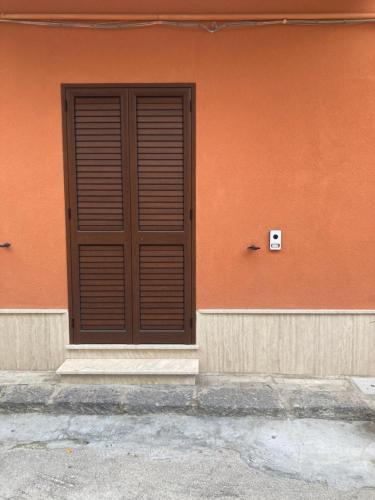 une porte brune sur le côté du bâtiment dans l'établissement Trotskyhouse, à Campobello di Licata