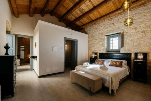 a bedroom with a large bed and a stone wall at Villa Torre Molino - IsulaTravel in Modica