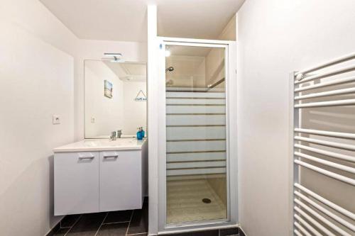 een badkamer met een wastafel en een spiegel bij résidence korejou plages in Plouguerneau