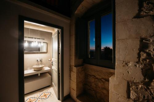 a bathroom with a sink and a window at Villa Torre Molino - IsulaTravel in Modica