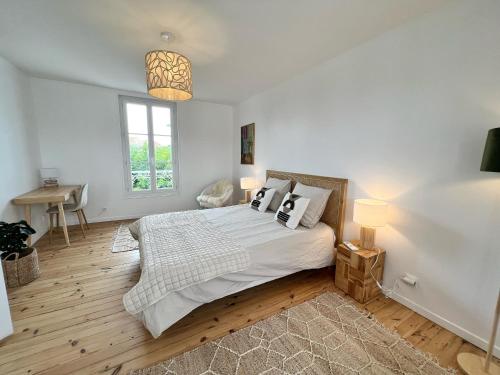 une chambre avec un grand lit et une fenêtre dans l'établissement La Sauvagère - Piscine, à La Rochelle