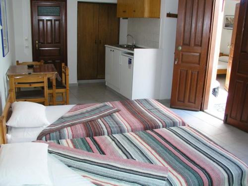 a bedroom with a bed and a table and a kitchen at SunStudios in Líndos