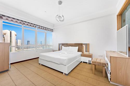 a white bedroom with a bed and a large window at Superhost Sea View Spacious 202 square meters apartment luxury property in Dubai