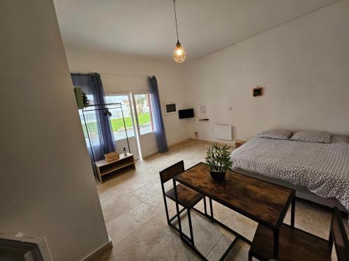 a bedroom with a bed and a wooden table with a table at Gitedelatournelleauxerre in Auxerre