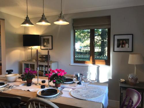 a dining room table with plates and wine glasses at Oak Crest, 2 bedrooms, log fire, scenic views near Chapel Down in Rolvenden