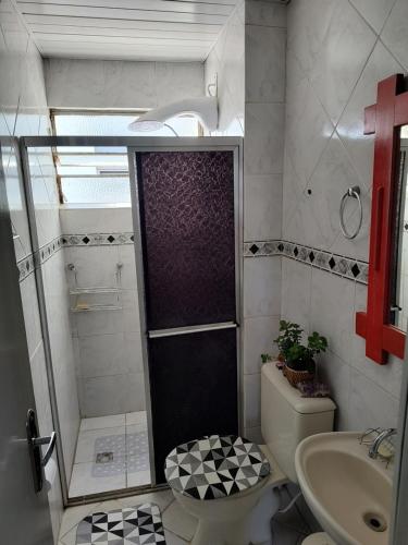 a bathroom with a shower and a toilet and a sink at A Felicidade Mora Aqui!!!! in Novo Hamburgo