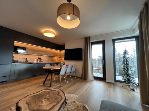 a kitchen and living room with a table and chairs at BlackDEER Apartment Liptov in Liptovský Mikuláš