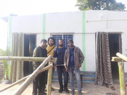 a group of men standing in front of a building at PALASH Pahar Resort in Jhalida