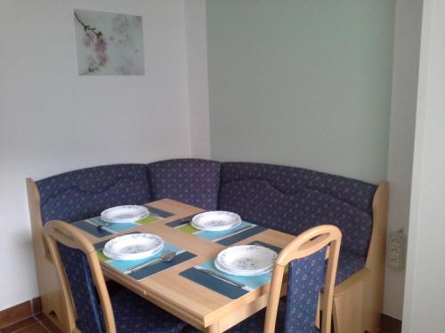 a table and chairs with a table and a couch at Apartment Zadraga in Tolmin