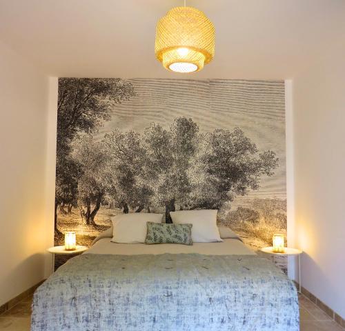 Schlafzimmer mit einem Bett mit Wandgemälde in der Unterkunft Maison d'hôtes La Bignone in Laudun